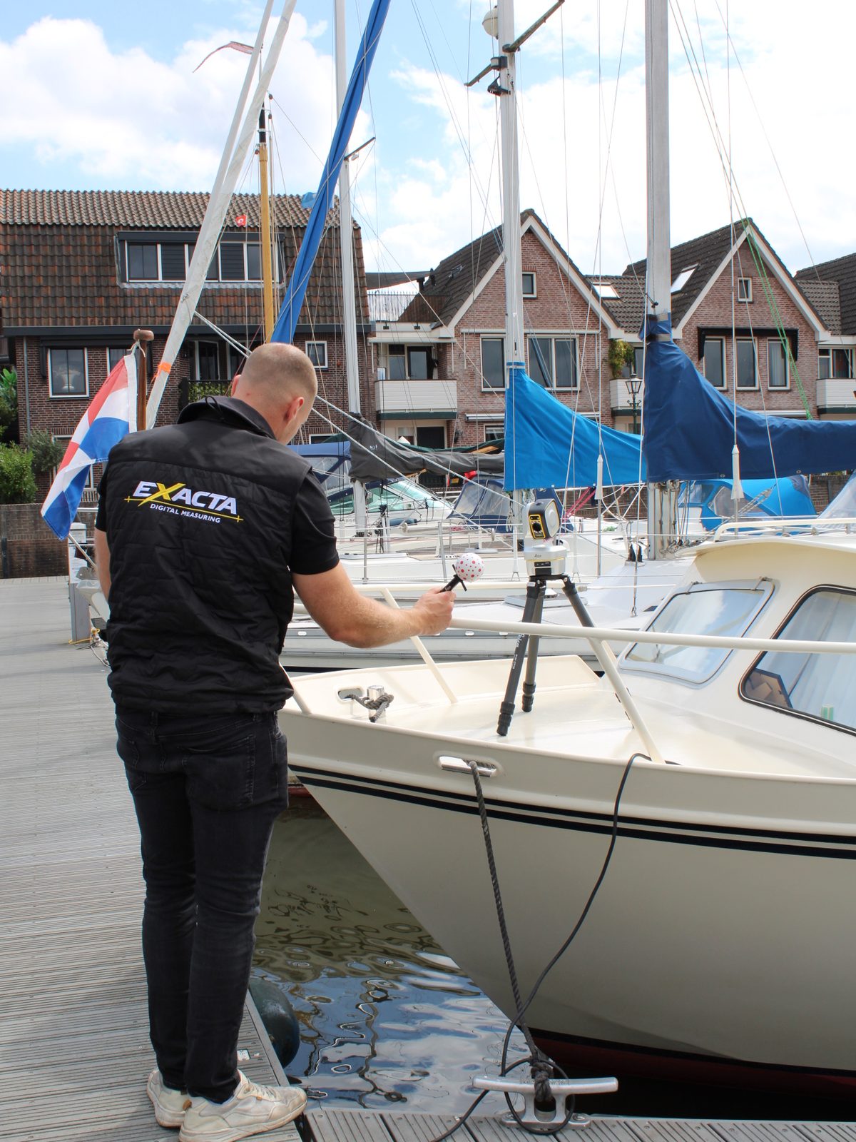 Medewerker legt meetpunten vast bij een jacht in de haven